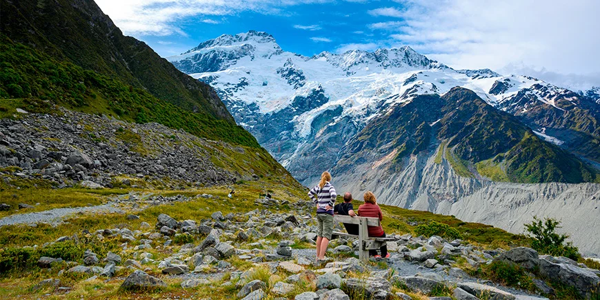 Een gezin van drie bekijkt de bergen vanaf het uitkijkpunt Kea Point in het Mount Cook National Park