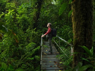 Een man staat op een brug in de Costa Ricaanse jungle