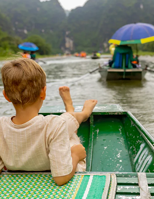 Een kind dat geniet van een boottocht in Ninh Binh, Vietnam