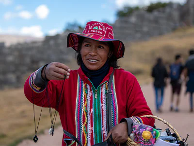 Lokale vrouw in Cusco, Peru, die handgemaakte sieraden verkoopt