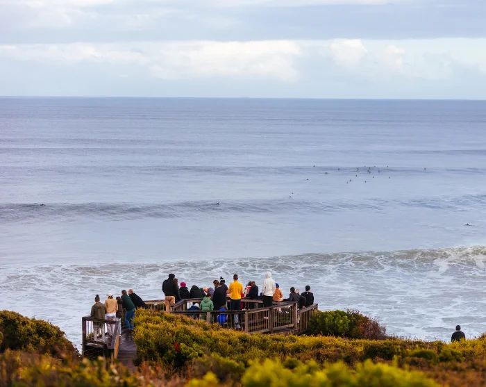Bells Beach in Australië, met mensen bij een uitkijkpunt met uitzicht over de zee en de golven