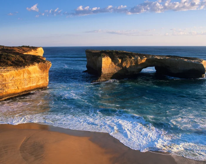 London Bridge langs de Great Ocean Road in Australië, een natuurlijke rotsboog in de blauwe zee naast een zandstrand