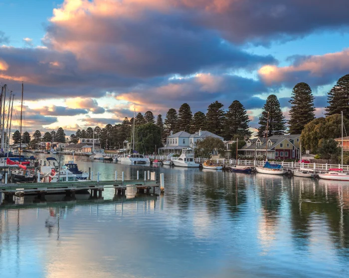 De Moyne-rivier in Port Fairy, Australië, met zeilboten in de haven, kleurrijke huizen en hoge bomen