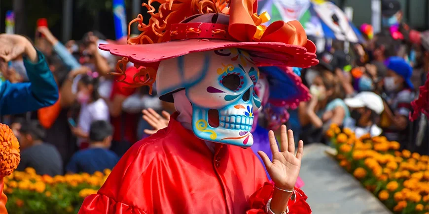 Persoon in kostuum tijdens een Dag van de Doden-parade in Mexico