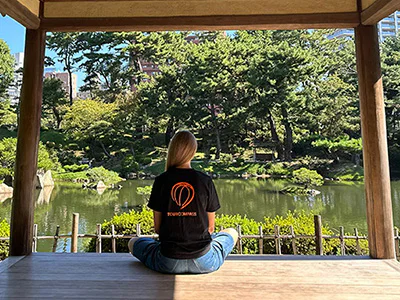 Vrouw in een TourCompass T-shirt in een prachtige Japanse tuin in Hiroshima