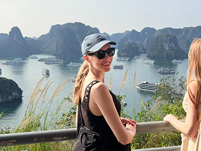 Iida kijkt in de camera met haar rug naar de Ha Long-baai