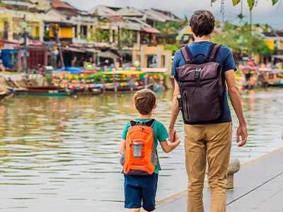 Vader en zoon lopen hand in hand door Hoi An