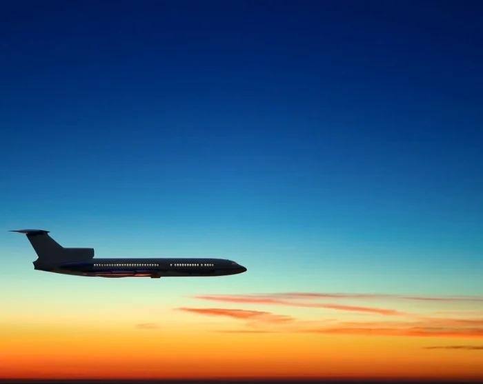 Vliegtuig in de lucht bij zonsondergang