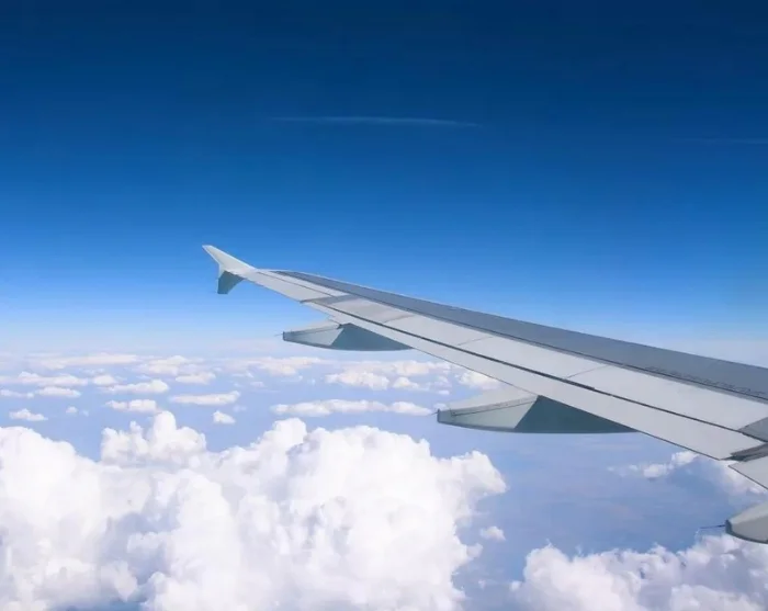 Vliegtuigvleugel boven de wolken op weg naar uw bestemming