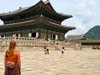 Vrouw kijkt naar het Gyeongbokgung-paleis in Seoel
