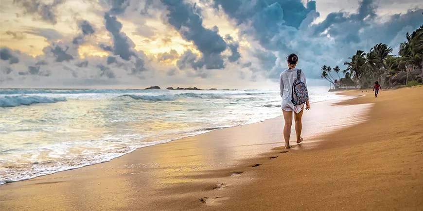 Vrouw die over het strand in Sri Lanka loopt