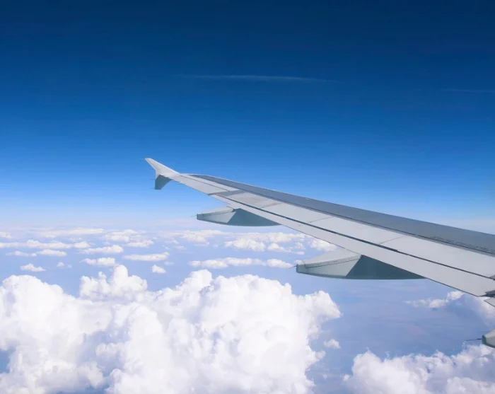 Vliegtuigvleugel boven de wolken op weg naar de bestemming