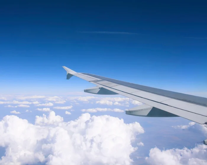 Vliegtuigvleugel boven de wolken op weg naar de bestemming