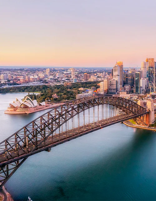 Luchtfoto van de Sydney Harbour Bridge in een paarse gloed.