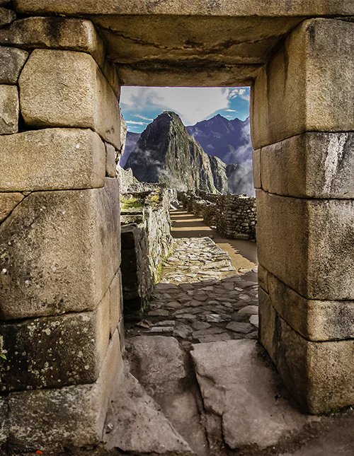 Stenen poort met uitzicht op Machu Picchu en de mistige Andes.