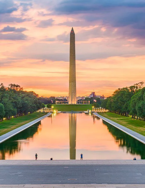 Het Washington Monument bij de Reflecting Pool in Washington, DC, VS, bij zonsopkomst.