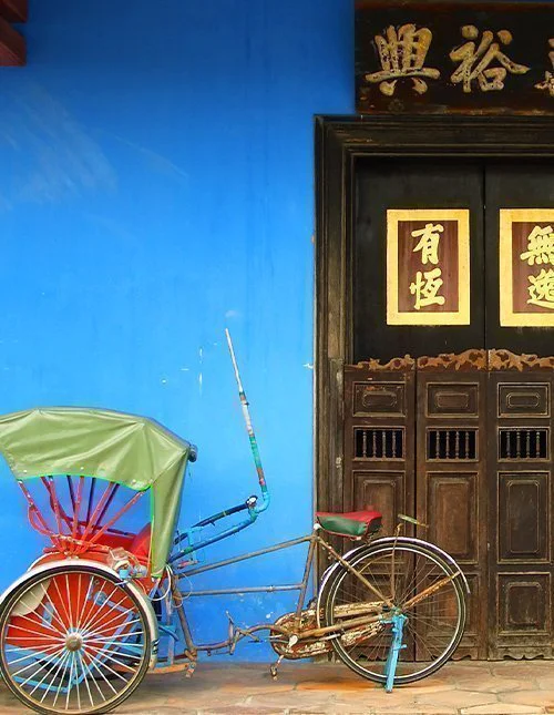 Blauwe deur van een Chinees huis met riksja in Singapore
