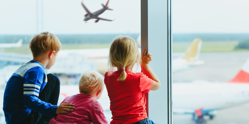 Drie kinderen wachten in de luchthaven