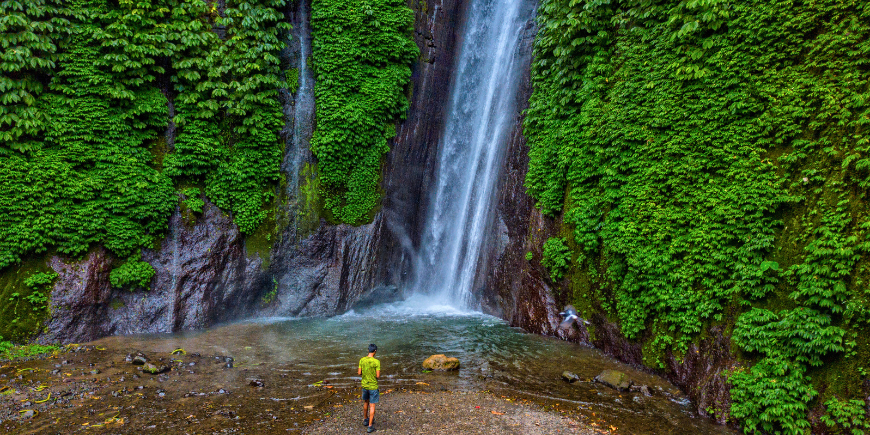 Man aan de voet van de Red Coral waterval in Munduk, Bali