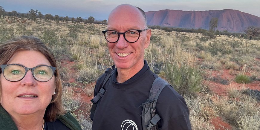 Beate en haar man nemen een foto voor Uluru in Australië