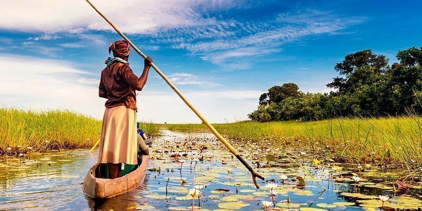 Vrouw varend in een boot in de Okavango Delta in Botswana