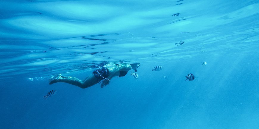 Vrouw snorkelt onder water in Zanzibar