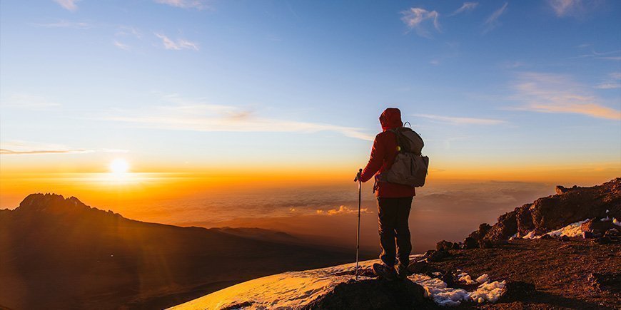 Man staat op Kilimanjaro bij zonsopgang