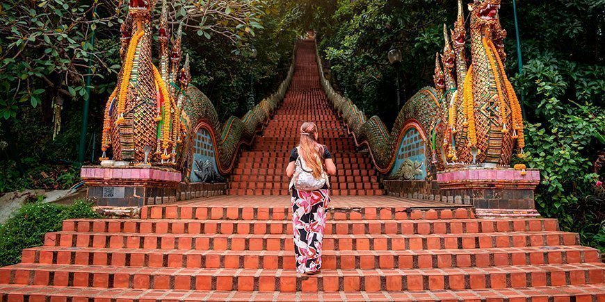 Vrouw beklimt de trappen van de Doi Suthep Tempel in Chiang Mai, Thailand.