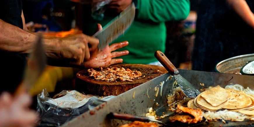 Vlees wordt klaargemaakt voor Taco's bij een eetkraampje in Mexico-Stad