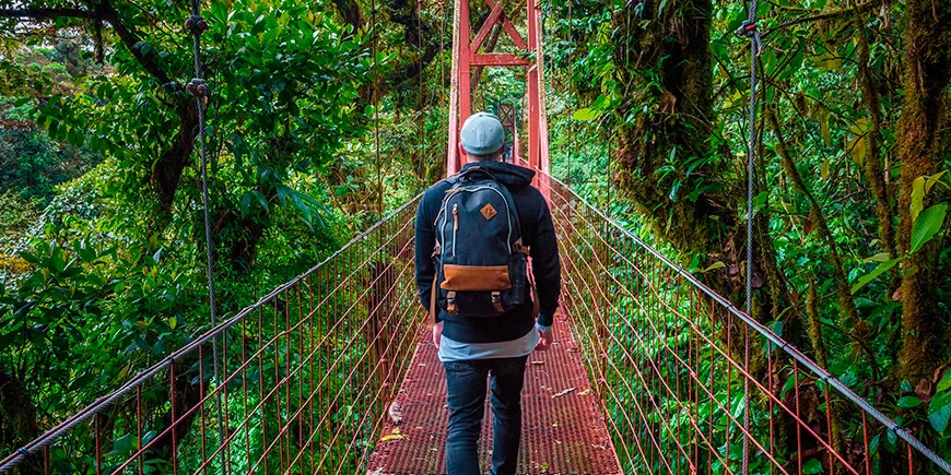 Man loopt alleen over een hangbrug in het nevelwoud van Monteverde in Costa Rica