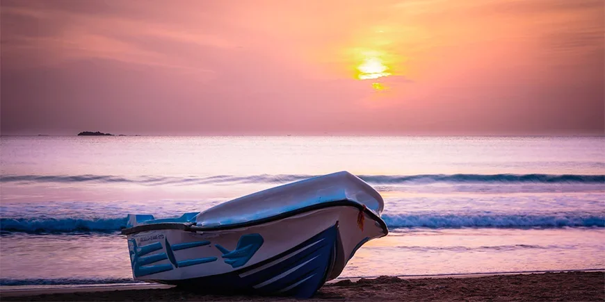 Boot bij zonsondergang voor de kust van Nilaveli Beach