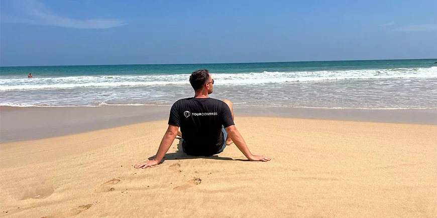 Een man in een TourCompass T-shirt op het strand van Mirissa, Sri Lanka