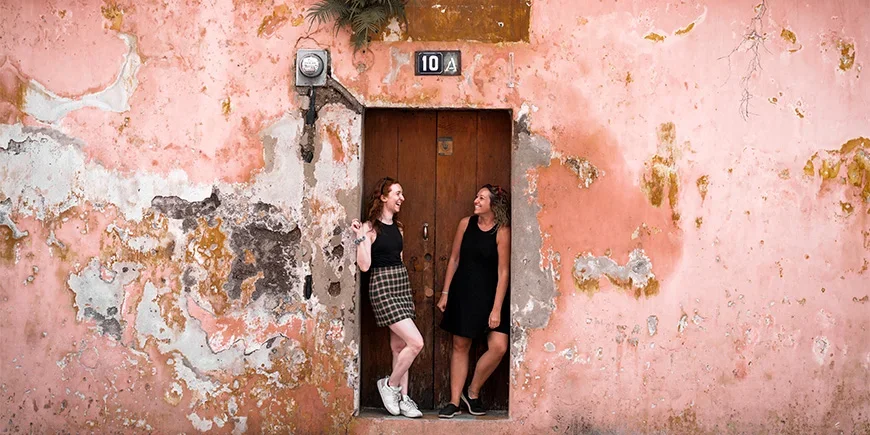 Twee vrouwen voor een kleurrijke muur in Antigua, Guatemala