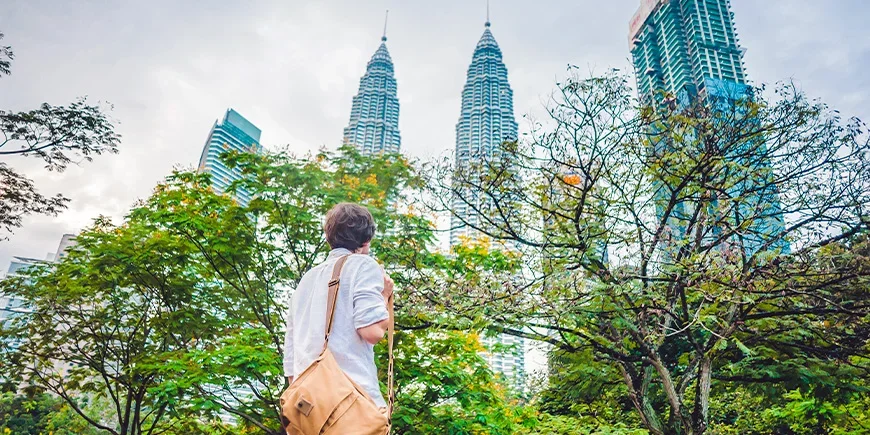 Man die naar de Petronas Twin Towers in Kuala Lumpur, Maleisië kijkt