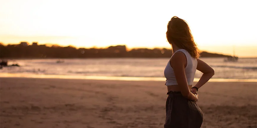 Vrouw die geniet van de zonsondergang op het strand van Tamarindo in Costa Rica