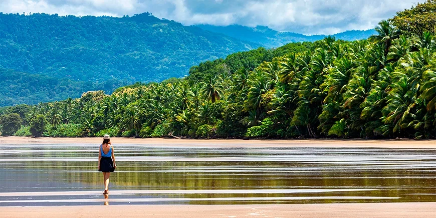 Vrouw die langs het water loopt op Manuel Antonio Beach in Costa Rica