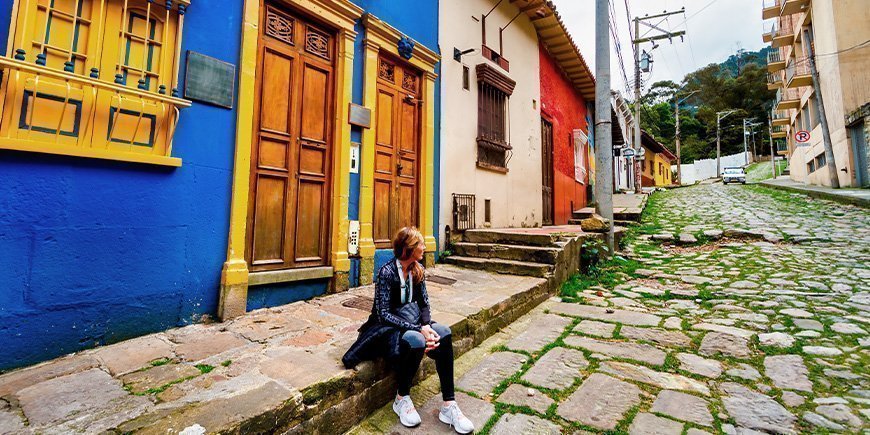 Zittende vrouw op straat in La Candelaria in Bogotá, Colombia