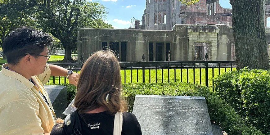 Japanse mannelijke gids met vrouwelijke toerist in Hiroshima, Japan