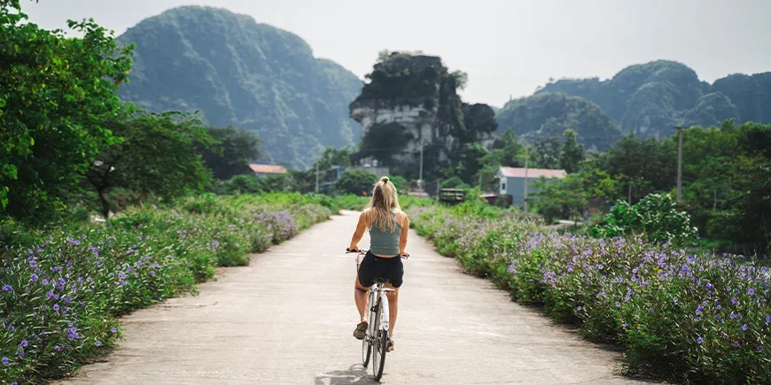 Vrouw die fietst over een rustige weg in Ninh Binh, Vietnam