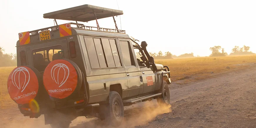 Jeep met TourCompass-logo die over de savanne in Kenia rijdt