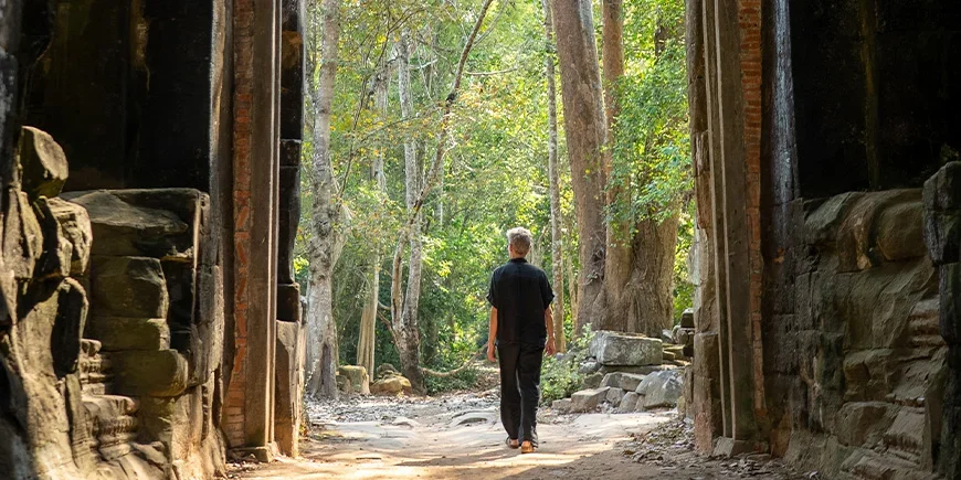 Man die door ruïnes in Cambodja loopt