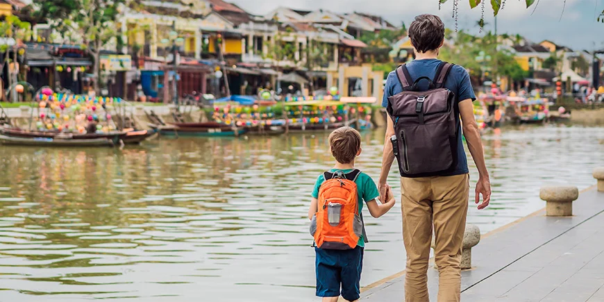 Vader en zoon lopen hand in hand in Hoi An