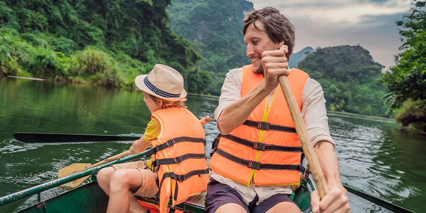 Vader en zoon varen in de buurt van Ninh Binh in Vietnam