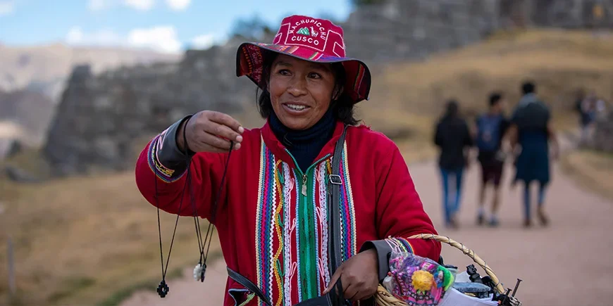 Lokale vrouw in Cusco, Peru, die handgemaakte sieraden verkoopt