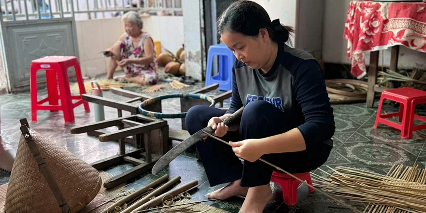 Vietnamese vrouw die souvenirs maakt van kokosnoten