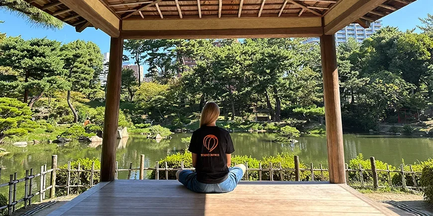 Vrouw in een TourCompass T-shirt in een prachtige Japanse tuin in Hiroshima