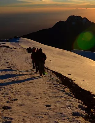 Trekkers bij zonsopgang op de top van de Kilimanjaro
